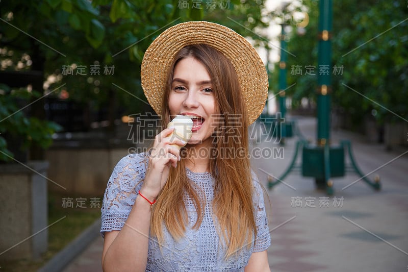 漂亮的女孩戴着夏天的帽子和冰淇淋