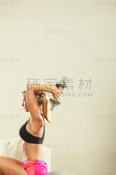 强壮的女性用哑铃锻炼。