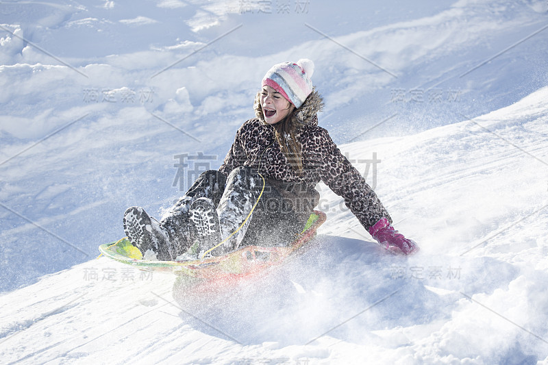 快乐和兴奋的女孩在雪天滑雪下山