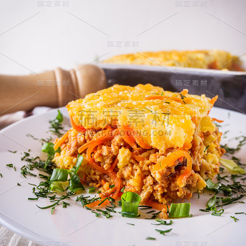 美味的土豆砂锅，肉和奶酪在白色的木制背景