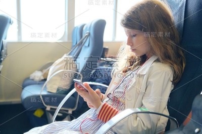 一名女孩坐在渡轮上使用智能手机