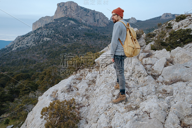 男人背包徒步旅行和红帽子在山区