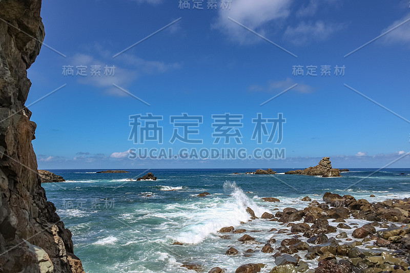 陡峭的熔岩峭壁。蓝色的大海地平线，自然的天空背景。