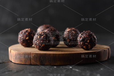 健康的原糖概念。自制的纯素能量球与生荞麦在木板上在黑暗的背景侧视图低关键的自然照明