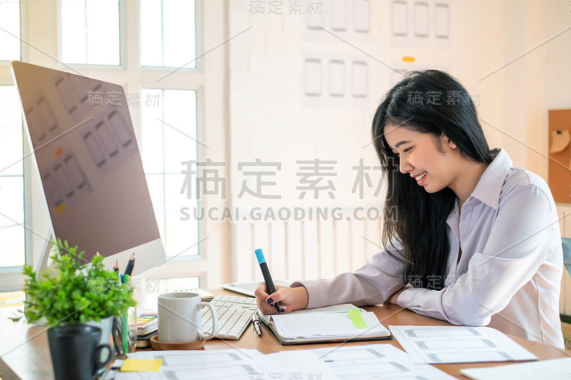 设计师女士在手机上绘制网站大纲和网站ux应用程序开发。