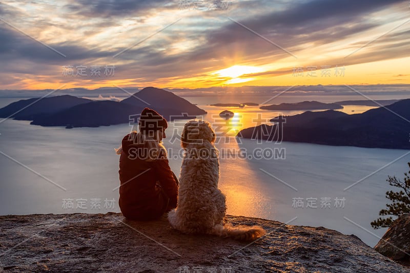 爱冒险的女孩带着狗在山顶徒步旅行