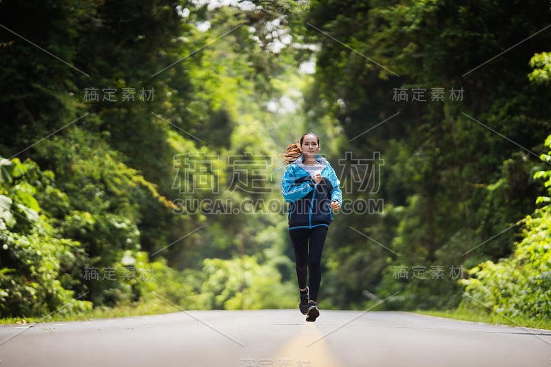 女人亚洲人她在早上她在森林里跑步