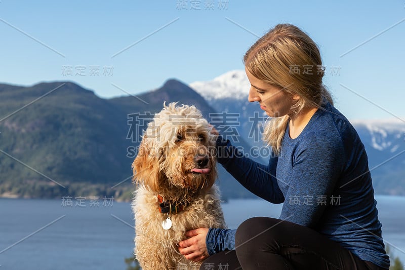 爱冒险的女孩带着狗在山顶徒步旅行