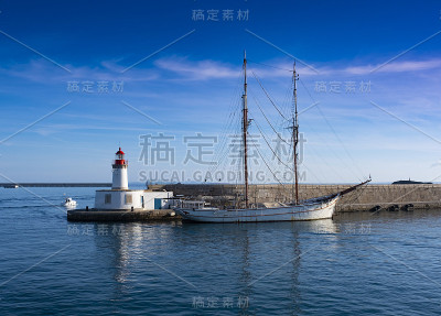 灯塔和帆船停泊在西班牙巴雷雷斯群岛伊比沙市的港口