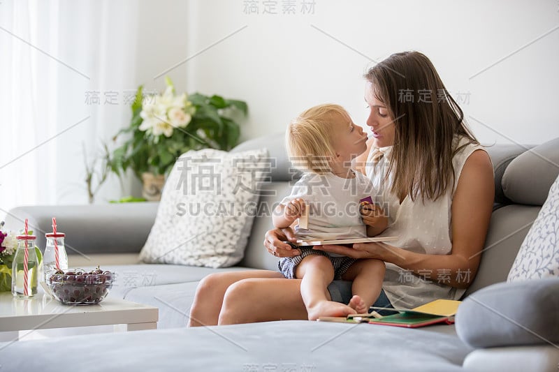 迷人的母亲，在家里和她可爱的蹒跚学步的儿子玩拼图游戏