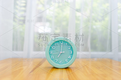 淡绿色闹钟放在卧室的桌子上