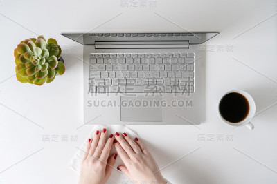 一名女工在开始工作前，用防病毒湿巾擦拭笔记本电脑和办公桌，以保护自己免受细菌和病毒的伤害。
