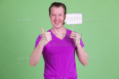 一个快乐的年轻人举着自拍照竖起大拇指