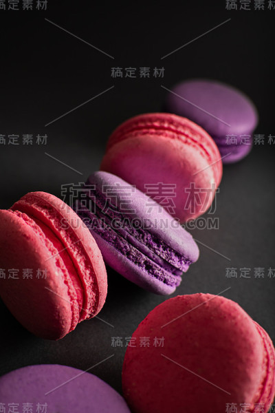 粉色和紫色的杏仁饼干在深色的背景上。国际妇女节。法国民族美食。食物。