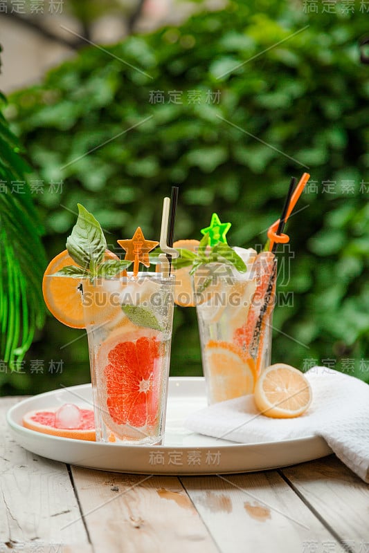 两杯鸡尾酒，冰柠檬水，莫吉托和排毒水与橙子，柠檬和葡萄柚片
