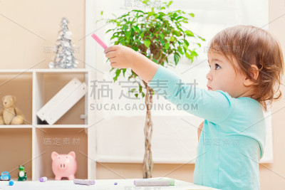 快乐的学步女孩玩粉笔