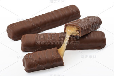 糖果棒，高热量的糖果和垃圾食品概念与普通焦糖，鸡块和饼干巧克力棒打破孤立的白色背景
