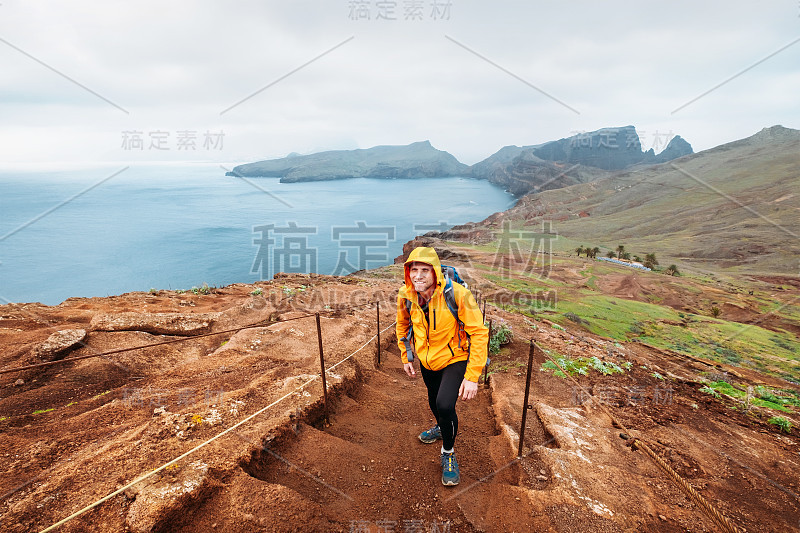 2月底，葡萄牙马德拉岛，年轻的男性背包客在Sao Lourenco岬角的小路上徒步旅行，可以看到大西