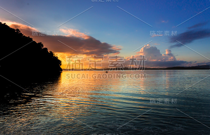 马达加斯加岛的海岸线，成行的树木和船只在日落时漂浮在海上