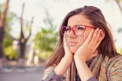 坐在户外，愁眉苦脸的女人