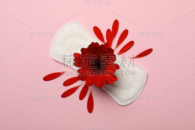 卫生棉与非洲菊在粉红色的背景，俯视图