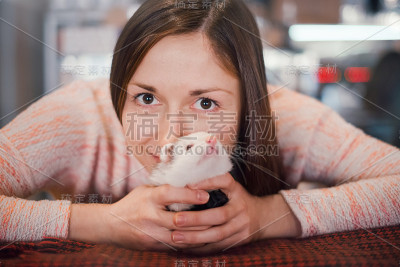 快乐的年轻女子抱着她的宠物雪貂