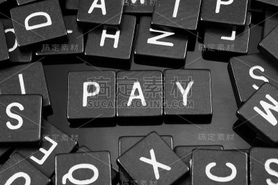 黑色字母瓷砖拼出单词“pay”