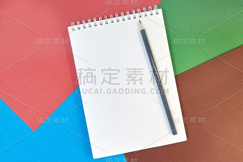 学习用品，打开笔记本，铅笔，纸上的彩色硬纸板背景与文字的地方。回到学校。教育和办学理念。平的。本空间