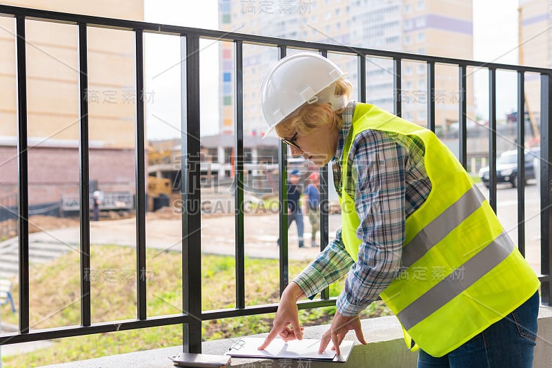 一位女建筑工在建筑工地检查建筑物