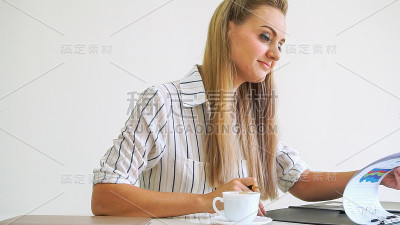 金发商务女性在现代办公室工作。