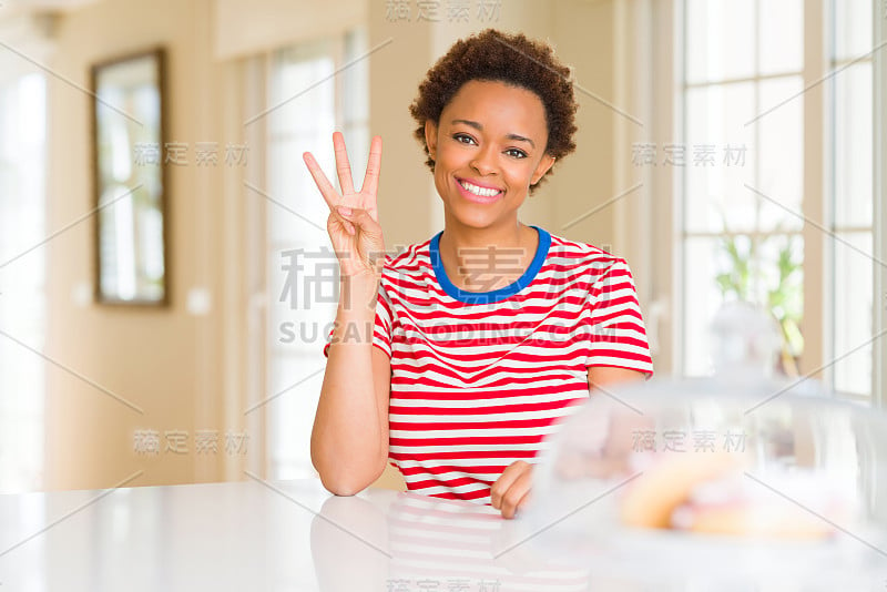 年轻美丽的非洲裔美国女人在家里用第三个手指指着别人，同时自信而快乐地微笑着。