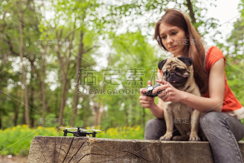 Quadrocopter。一个女孩带着一只哈巴狗启动了一架四轴飞行器