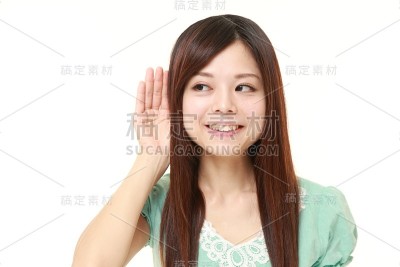 年轻女子把手放在耳朵后面仔细听着