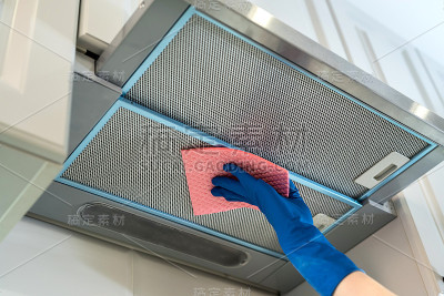 女性手在橡胶保护сleaning炊具罩与抹布在厨房。