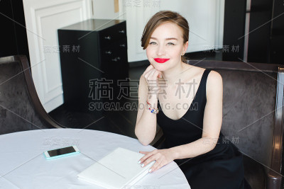 餐桌上拿着书的迷人女人