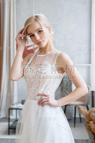 金发女孩穿着漂亮的白色婚纱。新娘在婚礼前等待新郎