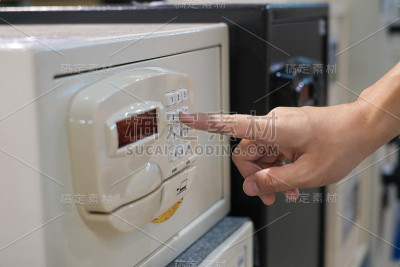 特写的手打开一个保险箱通过旋转一个数字旋钮。合成图像之间的一个手摄影