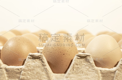 第一排鸡蛋用纸箱包装放在木桌上