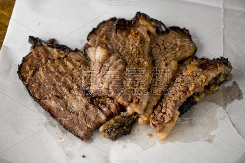 牛胸肉烧烤传统德州烟熏屋。揉搓香料和慢烟在一个经典的德克萨斯州烟屋在牧豆木屑在传统的经典烧烤方法。胸