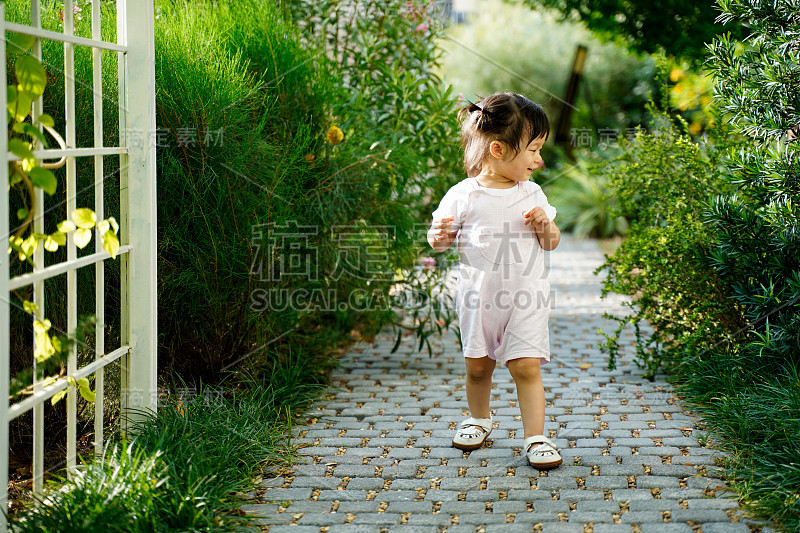 可爱的亚洲小女孩在户外咖啡厅餐厅花园。宝宝是好奇和环顾四周，孩子教育和发展学校的理念。