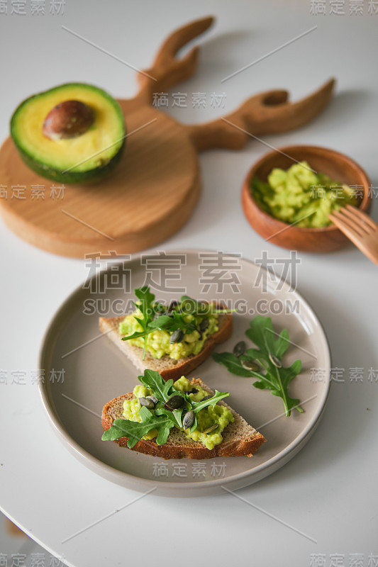 吐司配牛油果、芝麻菜和牛油果或鹿角形状的木板。碗鳄梨酱