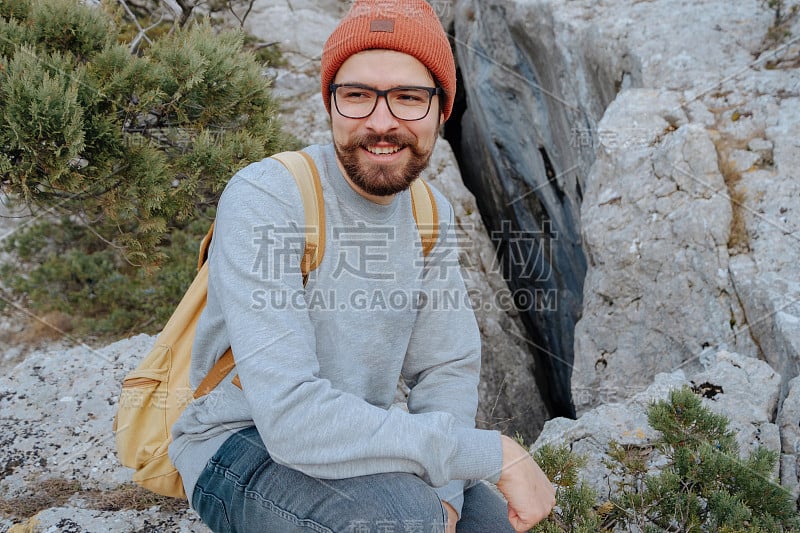 男人背包徒步旅行和红帽子在山区