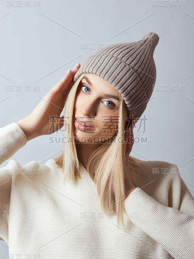 女人穿着春装，头巾，帽子和手套。那女孩金发碧眼。寒冷的春天穿暖和的衣服
