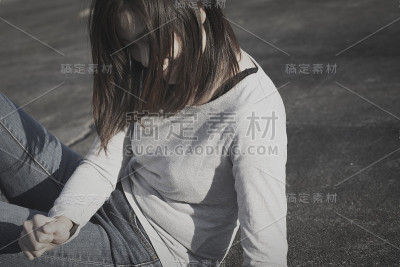 一位年轻的日本妇女坐在地上大笑。