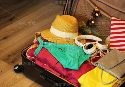 收集旅行用的手提箱。手提箱在开放视野的特写与东西休息在一个木制的背景