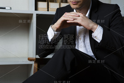 一个商人坐在书架前的椅子上