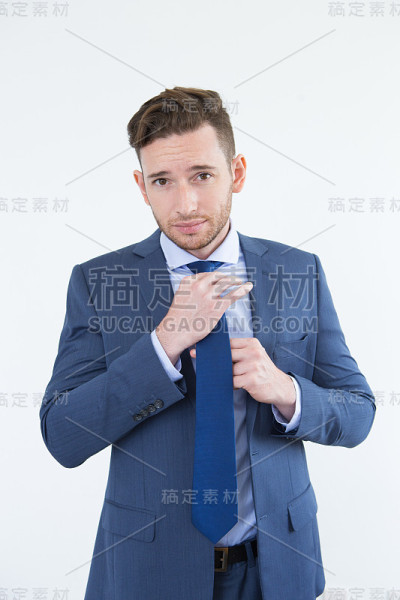 傲慢英俊的年轻商人调整领带