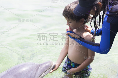 假期生活方式-快乐男孩拥抱海豚