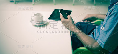喝咖啡休息时拿着智能手机的商人