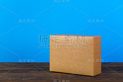 空的封闭的棕色纸板箱模拟在深色木桌上与拷贝空间。
